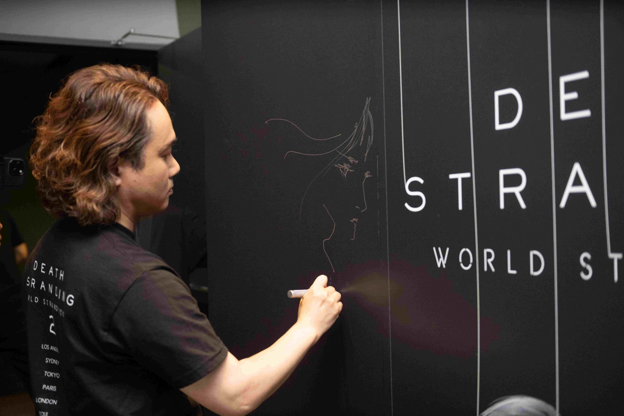 圖片二美術總監新川洋司親自在《DEATH-STRANDING-2-ON-THE-BEACH》活動現場簽名